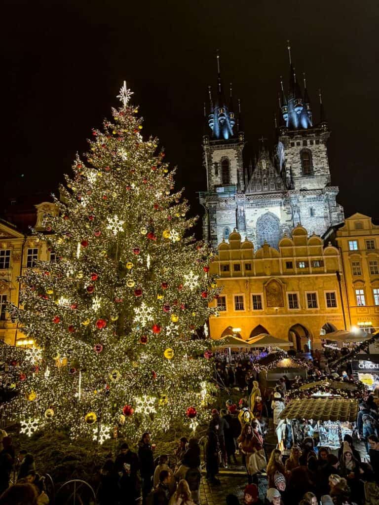 A Christmas tree with the backdrop of a Gothic church at the Old Town Square Christmas Market in Prague