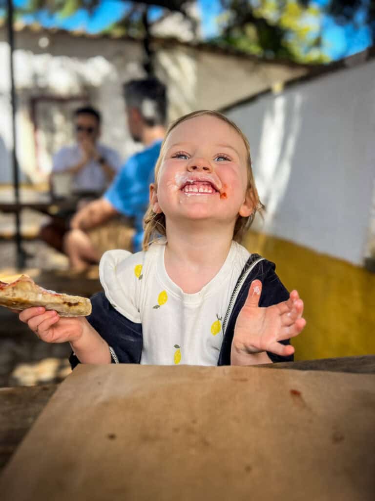Juniper eating pizza in Portugal